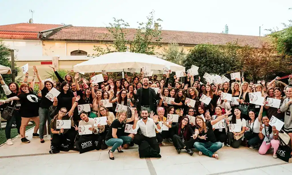 Foto di gruppo che ritrae Imprenditore, Insegnanti e Studenti con in mano il loro diploma dopo aver terminato un corso di formazione. Tutti in questa foto sorridono.